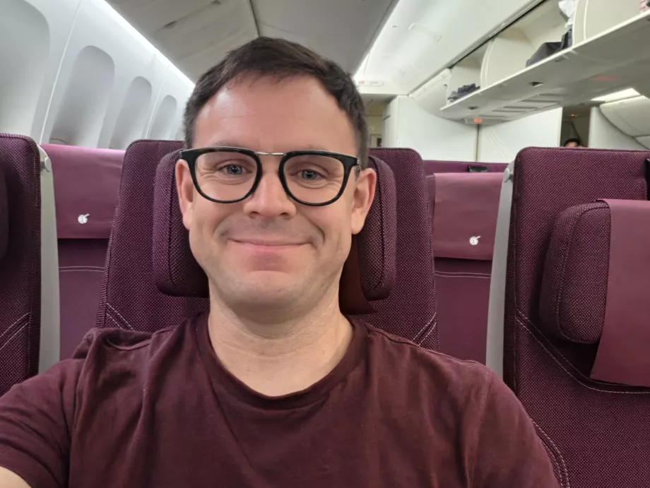 Yo en Qatar Airways (¡mi camiseta combina con los colores de la cabina!)
