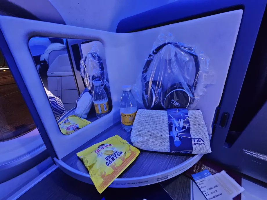 Panel de apertura con espejo, auriculares, galletas y agua