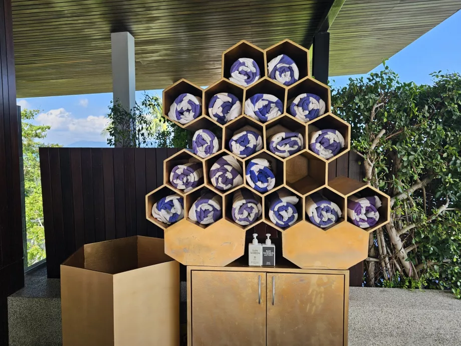 Toallas y crema solar junto a la piscina